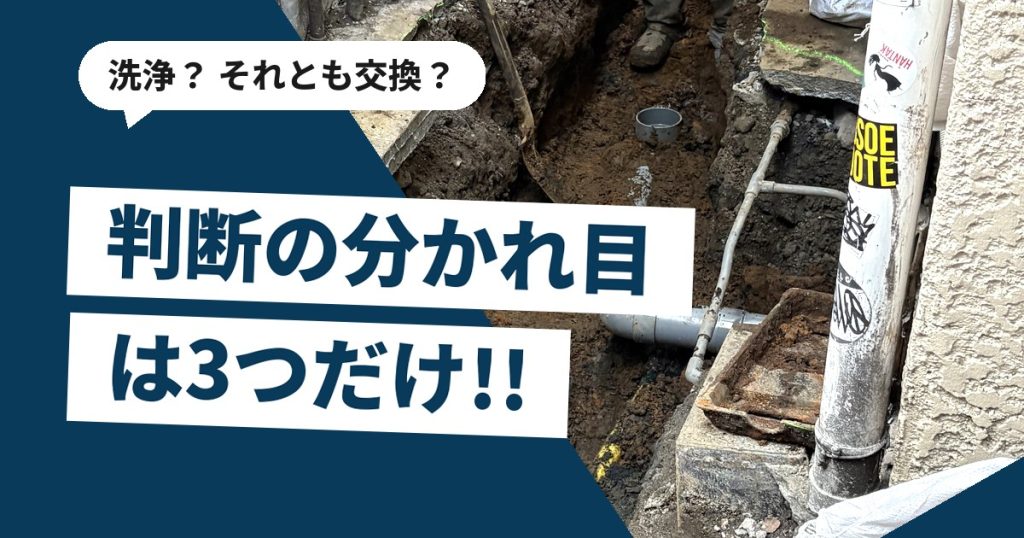 狭い路地に面した店舗の前で排水管の入れ替え工事を行っている現場